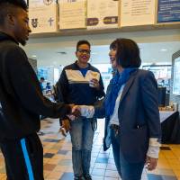 President Mantella talking with families and shaking hands with student.